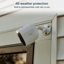 an arlo spotlight security camera affixed to the side of a house