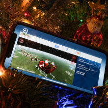 NORAD Tracks Santa app on a smartphone in a christmas tree 