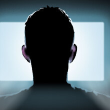 Seen from behind, an illustrated man looks at a glowing computer screen.