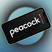 phone with Peacock app logo on screen and blue background