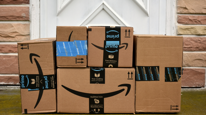 pile of Amazon packages at doorstep of home