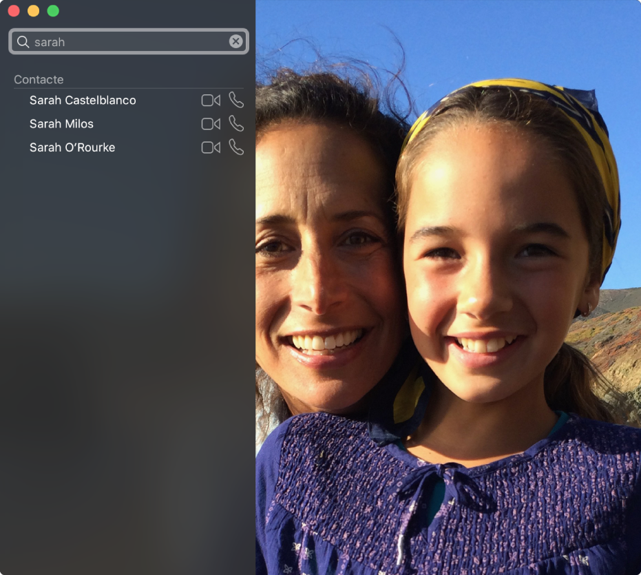 Fereastra FaceTime înainte de efectuarea unui apel. În colțul din stânga sus este un câmp de căutare, în care este introdus cuvântul “Sarah”, iar dedesubt se află o listă de rezultate ale căutării, prezentând contacte care se numesc Sarah, cu butoane lângă fiecare contact care vă permit să efectuați un apel video sau audio. În partea dreaptă este imaginea de la cameră: două persoane gata să inițieze un apel.