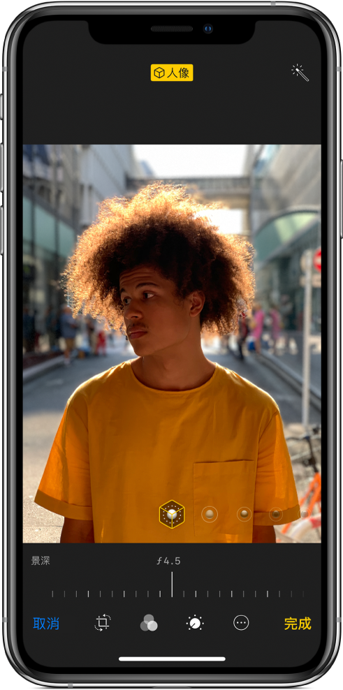 「人像」模式照片的「編輯」畫面。照片位於畫面中央，照片下方的滑桿用來調整「景深控制」。滑桿下方由左至右分別為「取消」、「裁切」、「濾鏡」、「計時器」、「更多」和「完成」按鈕。