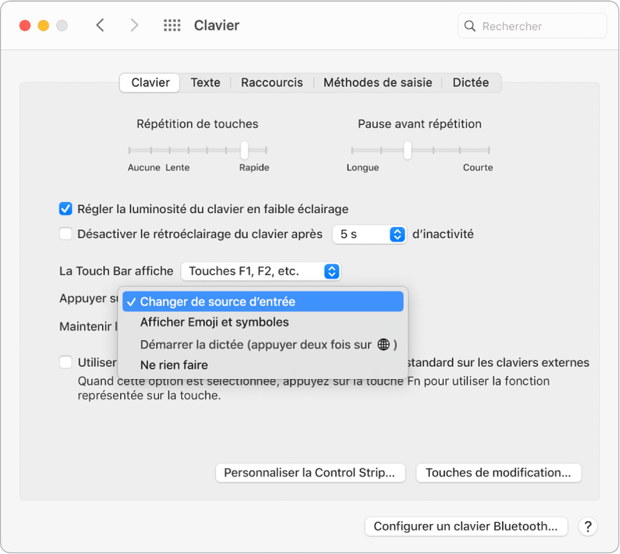 La sous-fenêtre des préférences Clavier, avec un menu déroulant affichant des options pour la touche Fonction/Globe : « Changer de source d’entrée », « Afficher Emoji et symboles », « Démarrer Dictée » et « Ne rien faire ».