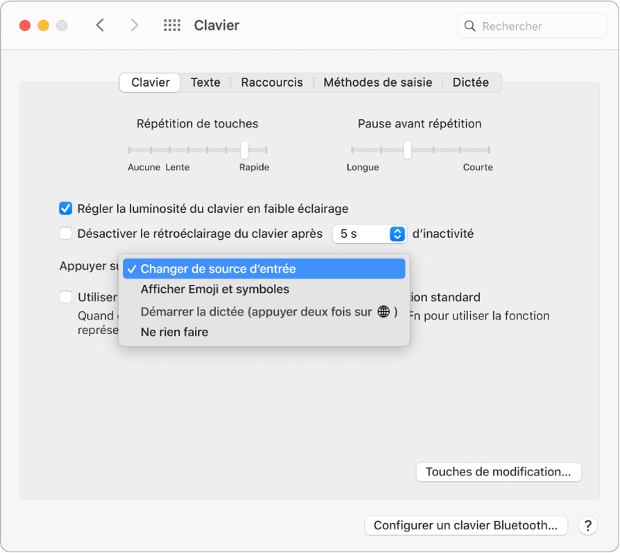 La sous-fenêtre des préférences Clavier, avec un menu déroulant affichant des options pour la touche Fonction/Globe : « Changer de source d’entrée », « Afficher Emoji et symboles », « Démarrer Dictée » et « Ne rien faire ».