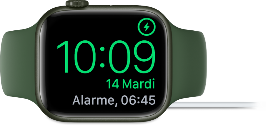 Apple Watch placée sur sa tranche et connectée au chargeur. L’écran montre le symbole de recharge dans le coin supérieur droit, l’heure actuelle en dessous et l’heure du prochain réveil.