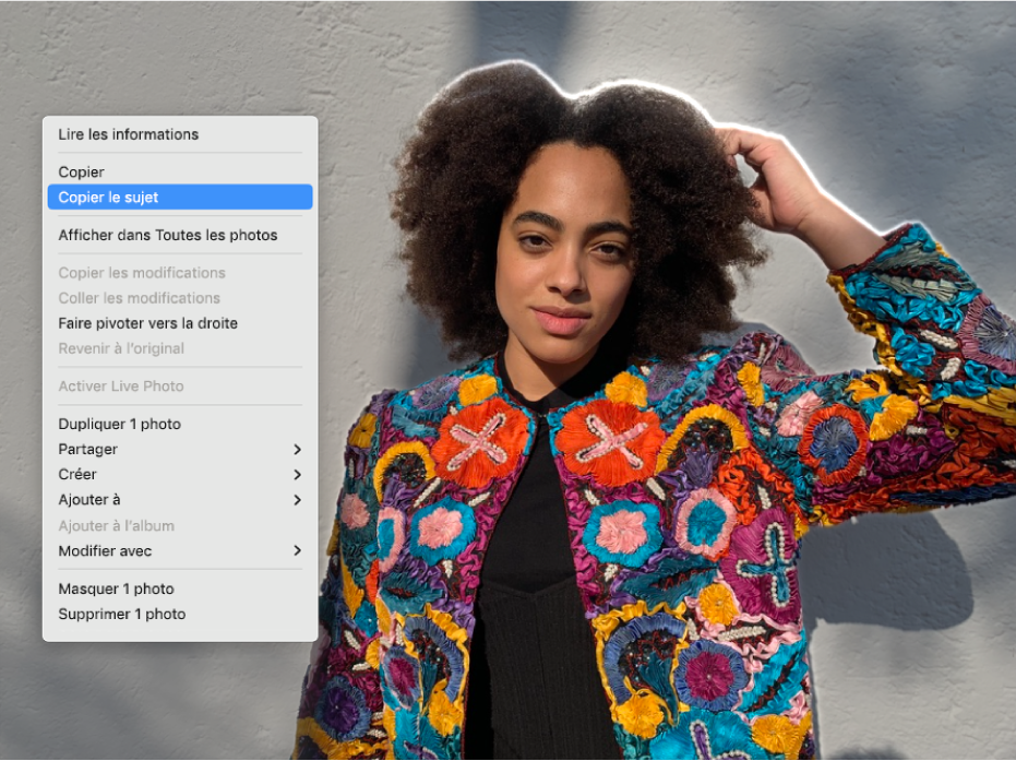 Un contour apparaît autour d’une personne qui se trouve au premier plan d’une photo, et un menu montre l’option « Copier le sujet » sélectionnée.