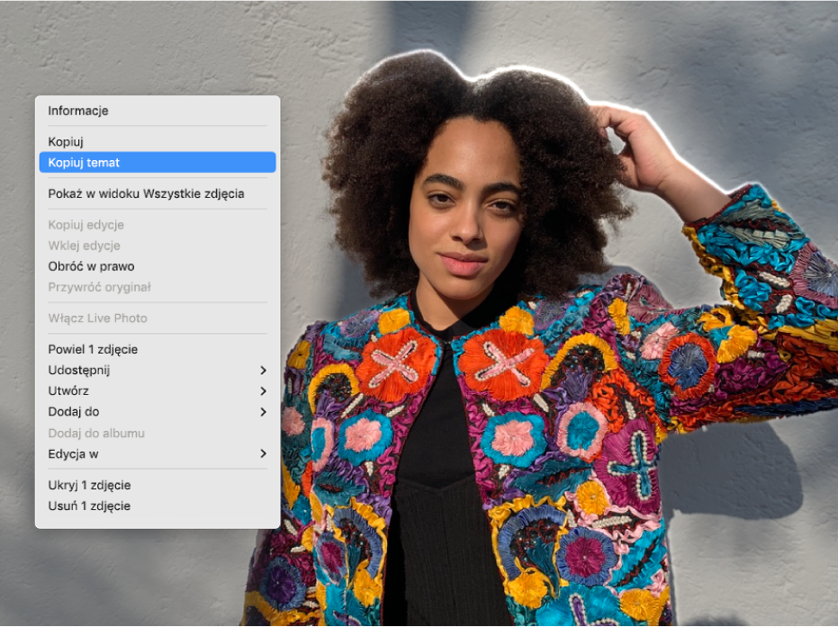Obrys wokół osoby widocznej na pierwszym planie zdjęcia oraz menu z wybranym poleceniem Kopiuj temat.