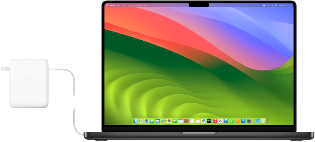 ‏MacBook Pro مقاس 16 بوصة موصول بمحول الطاقة.