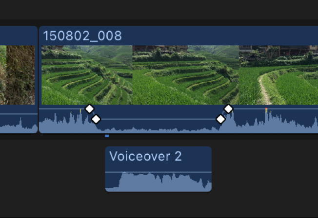 时间线中的视频片段显示已降低音量部分一端的关键帧，突出了下方连接的画外音音频片段