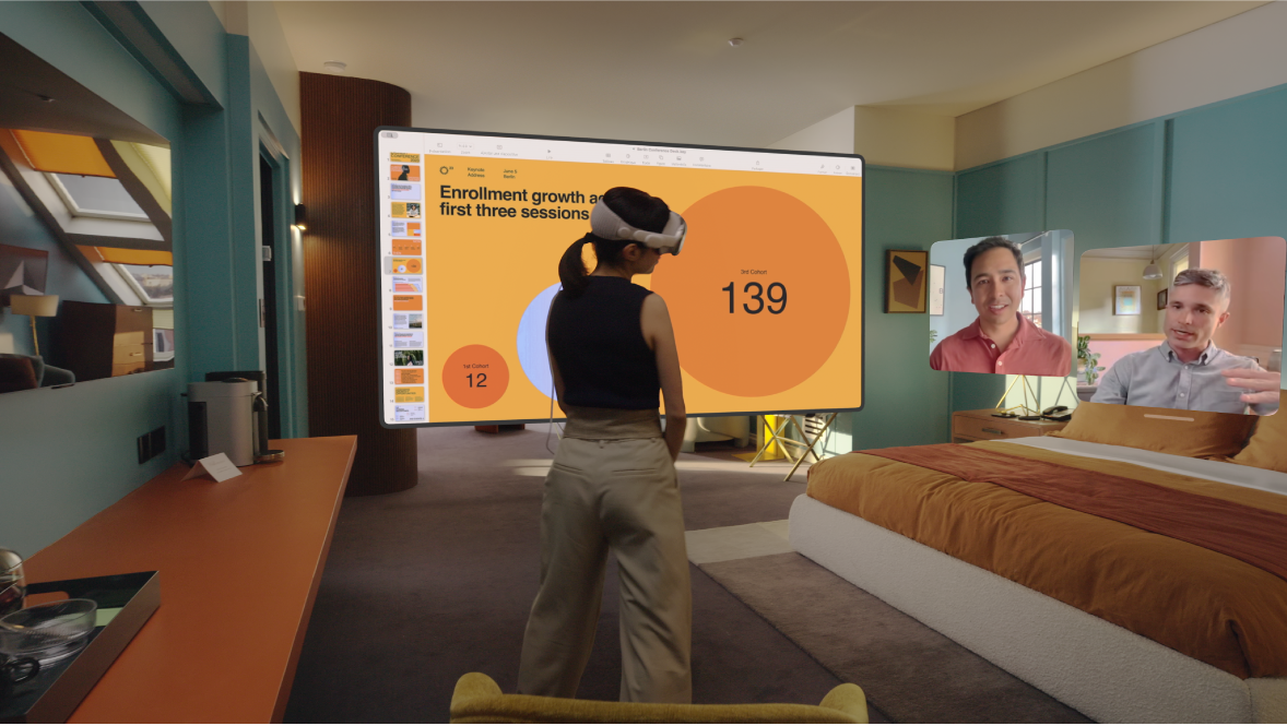 Une personne portant un Apple Vision Pro et en train de passer un appel FaceTime. Les vignettes des autres personnes participant à l’appel sont visibles à côté d’un écran partagé.