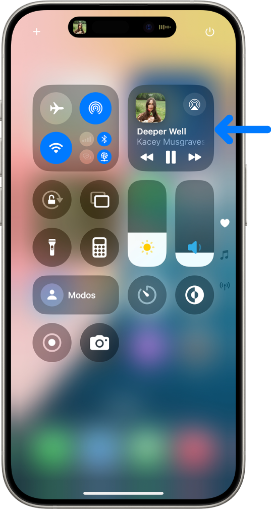 El centro de control del iPhone con una flecha que apunta a la tarjeta de audio con la que puedes controlar la música desde la pantalla de bloqueo o si estás usando otra app.