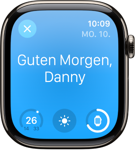 Apple Watch zeigt die Begrüßung beim Aufwachen. Oben wird „Guten Morgen“ angezeigt. Die Temperatur, die Wetterkonditionen und der Batterieladestand werden darunter angezeigt.