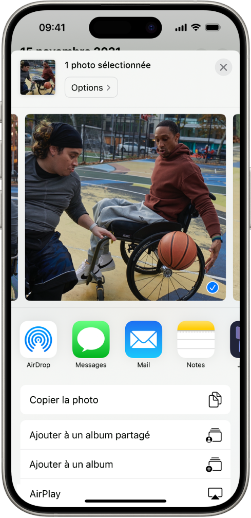 Une photo sélectionnée est affichée dans la moitié supérieure de l’écran de l’iPhone. Une rangée d’options de partage se trouve en dessous. Des options supplémentaires figurent en bas, notamment « Copier la photo », « Ajouter à un album partagé », « Ajouter à un album » et AirPlay.