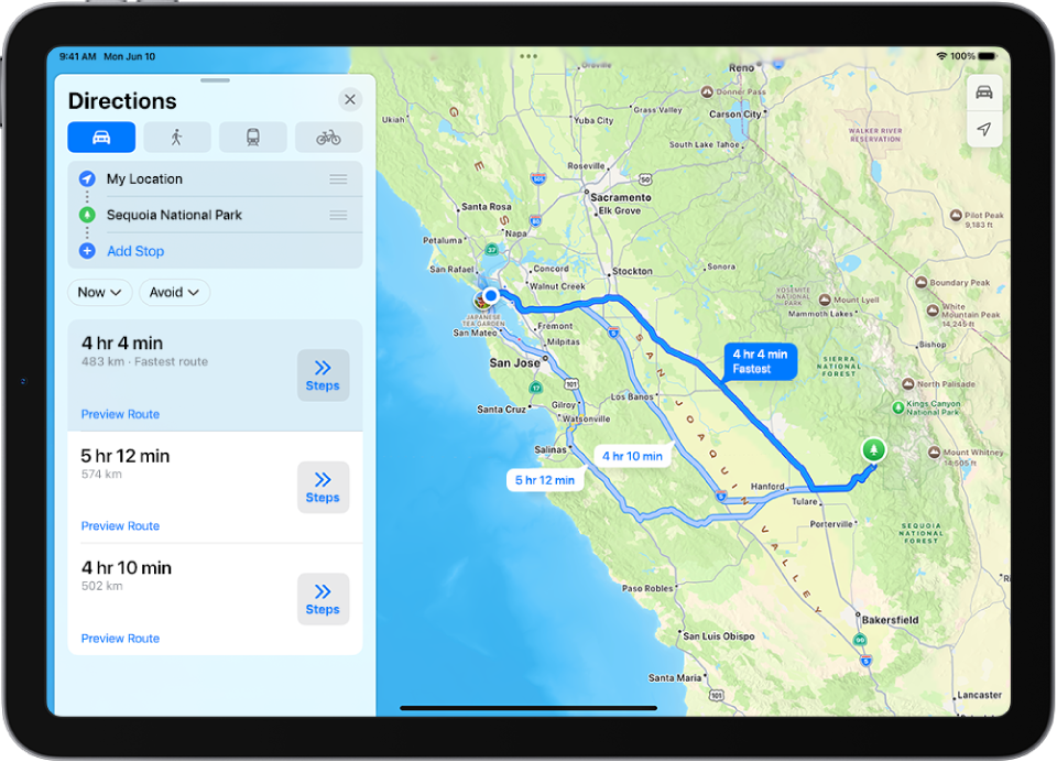 En iPad, der viser et kort med flere ruter i bil til den samme destination. Hver rute viser den estimerede tid og afstand, og knappen Trin viser detaljeret vejvisning. Farvekodning på hver rute angiver trafikforholdene.