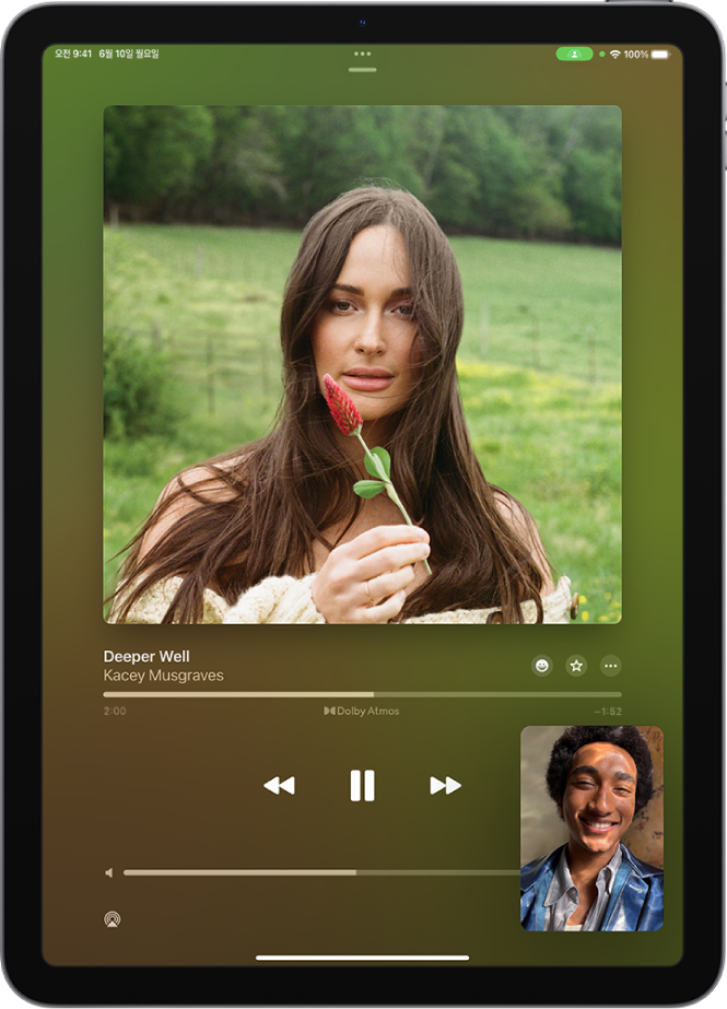Apple Music 콘텐츠가 동기화되어 통화에 참여 중인 모든 사람과 공유되고 있는 SharePlay 세션이 표시된 FaceTime 통화. 오른쪽 하단에 콘텐츠를 공유하는 사람의 이미지가 표시되어 있으며, 화면 상단 부근에 공유 중인 앨범의 이미지가 있고, 앨범 이미지 아래에 재생 제어기가 있음.
