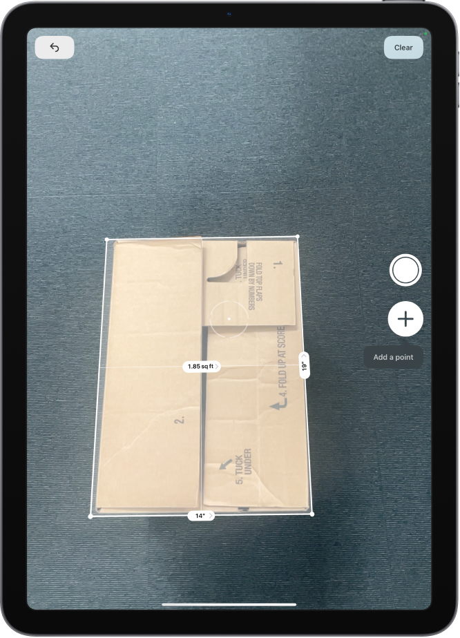 A screen showing the measurement of the dimensions of a box in the Measure app. The area of the box is calculated from the measurements of the dimensions.