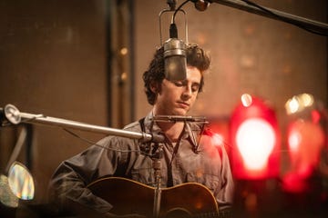 A musician performing with a guitar in a recording studio