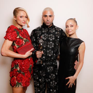 three individuals posing together one holding an award