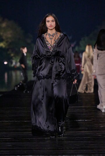 model showcasing a luxurious black outfit on a runway