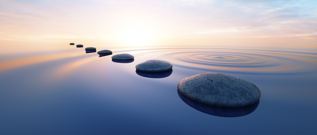 row of stones in calm water in ocean