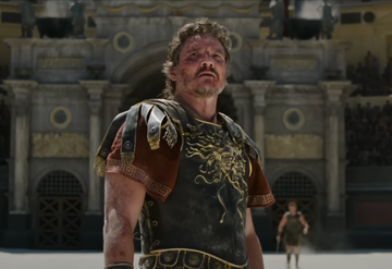 gladiator in armor stands in an arena