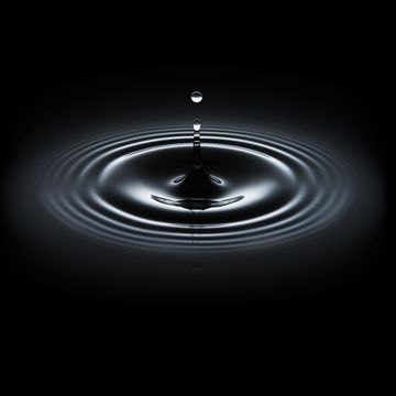 water drop making ripple on black background