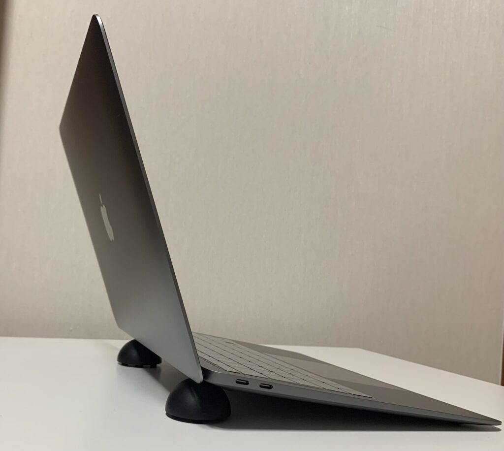 半円のノートパソコンスタンドに乗せたMacBook Air