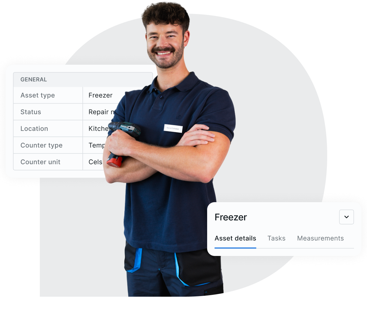 Smiling maintenance technician in a navy uniform holding a drill, with an asset management interface overlay displaying details of a freezer