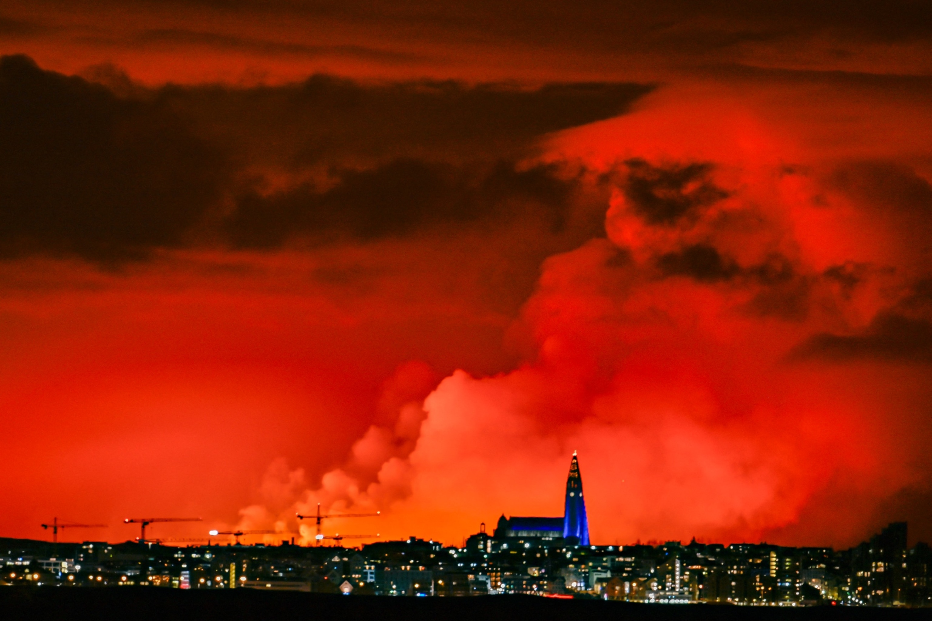 PHOTO: This photograph shows the skyline of Reykjavik against the backdrop of orange coloured sky due to molten lava flowing out from a fissure on the Reykjanes Peninsula, March 16, 2024. 