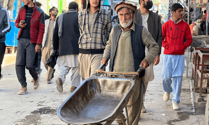 A daily wage worker stands in the midst of chaos.