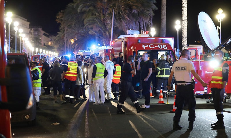 Police officers, firefighters and rescue workers are seen at the site of an attack on July 15, 2016— AFP or licensors