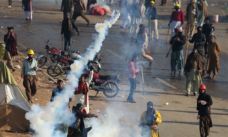 A TLP protesters throws a tear gas shell back towards police during a clash in Islamabad on Nov 25, 2017. ─ AFP/File