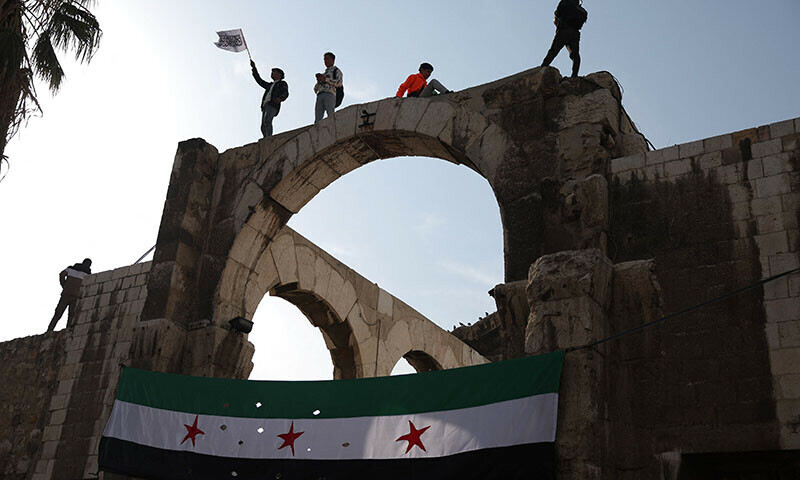 Syrians wave the independence-era flag after Friday Noon prayers at the Umayyad Mosque in the capital Damascus on Dec 20, 2024. — AFP