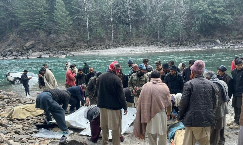 Residents and rescue workers gather around the bodies recovered from a car that plunged into icy Neelum river near Nagdar Kinari village of Neelum valley on Tuesday. — Photo by author