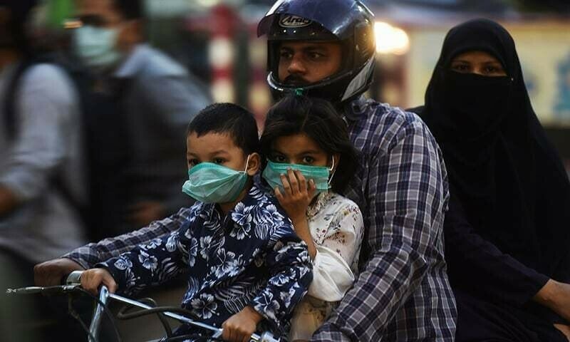 Children riding on a bike with their family wear facemasks as a preventive measure against the Covid-19 coronavirus, in Karachi on October 29, 2020. - A mandatory mask order came into force in Pakistani cities on October 29 in a bid to prevent a second wave of coronavirus cases in the impoverished country as winter approaches.  — AFP/File