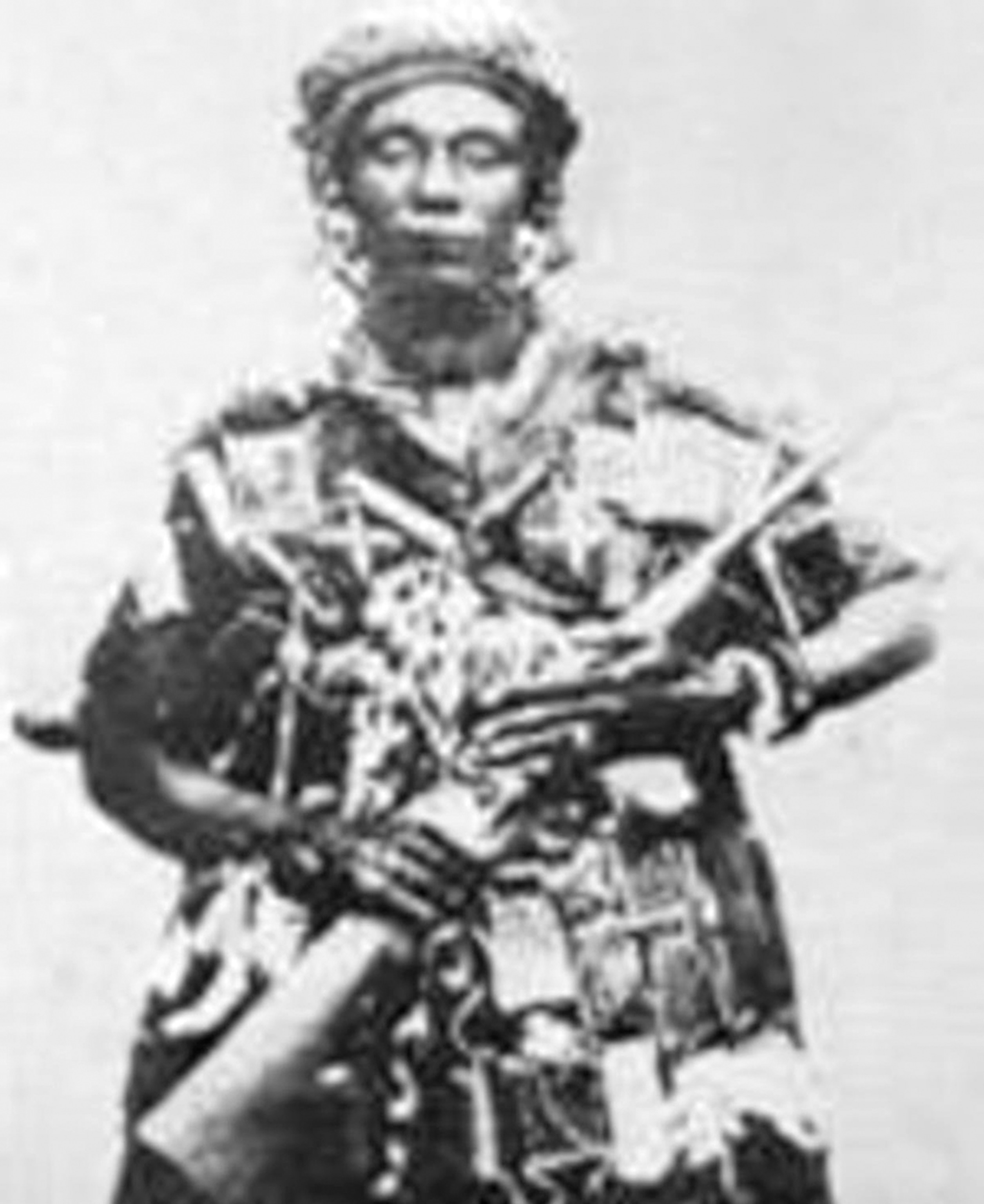 Picture of old black and white photo of armed woman in traditional dress.