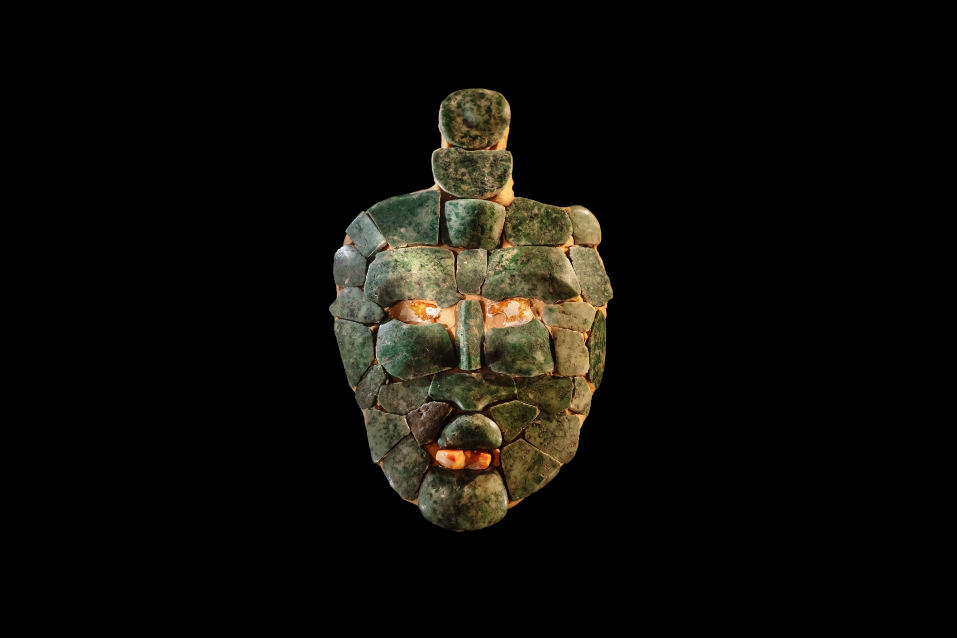 a mosiac mask with a blue tint. The eyes, nose and lips are clearly defined.