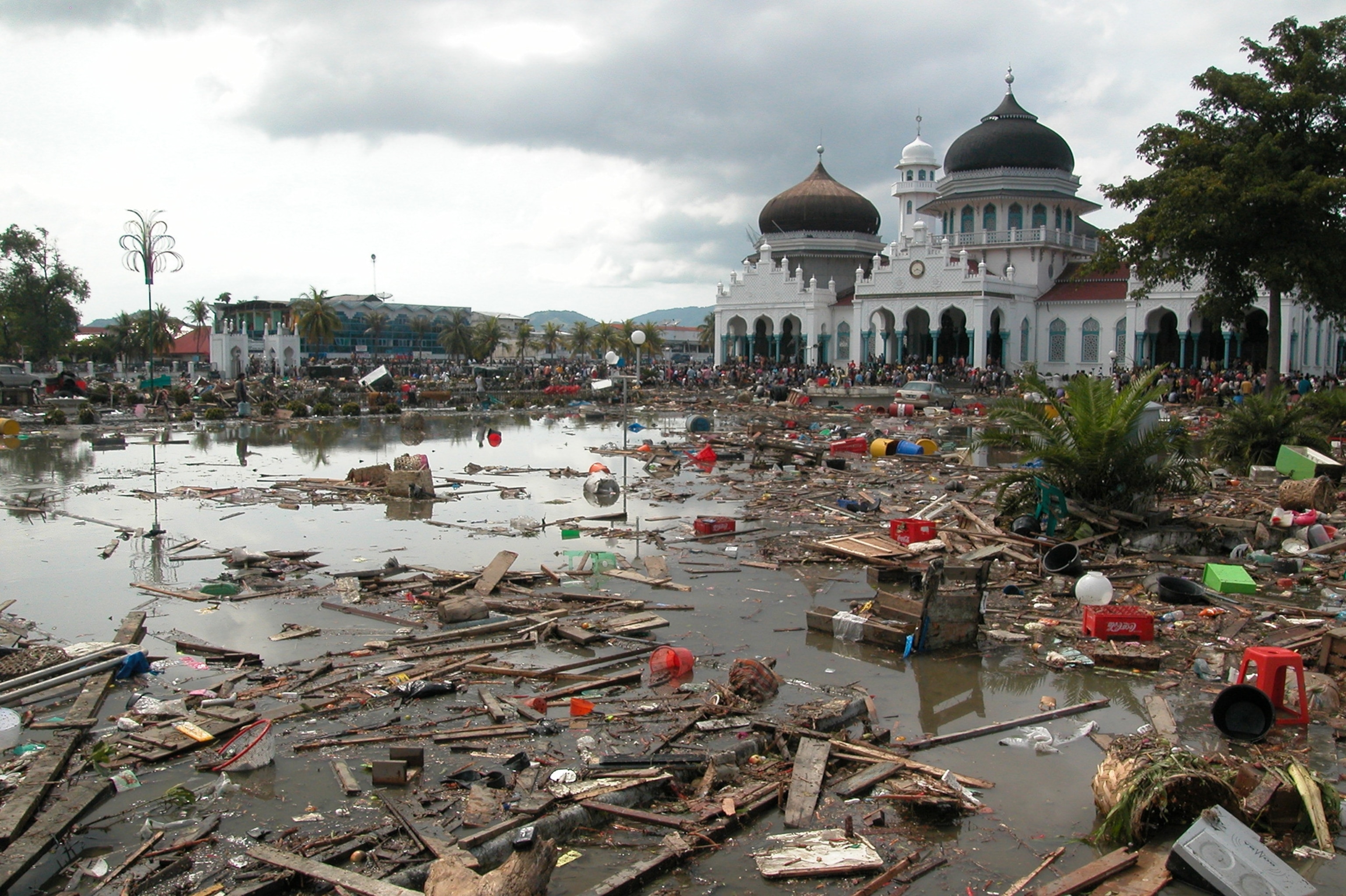 Debris fills the landscape with a Mosque in the background.