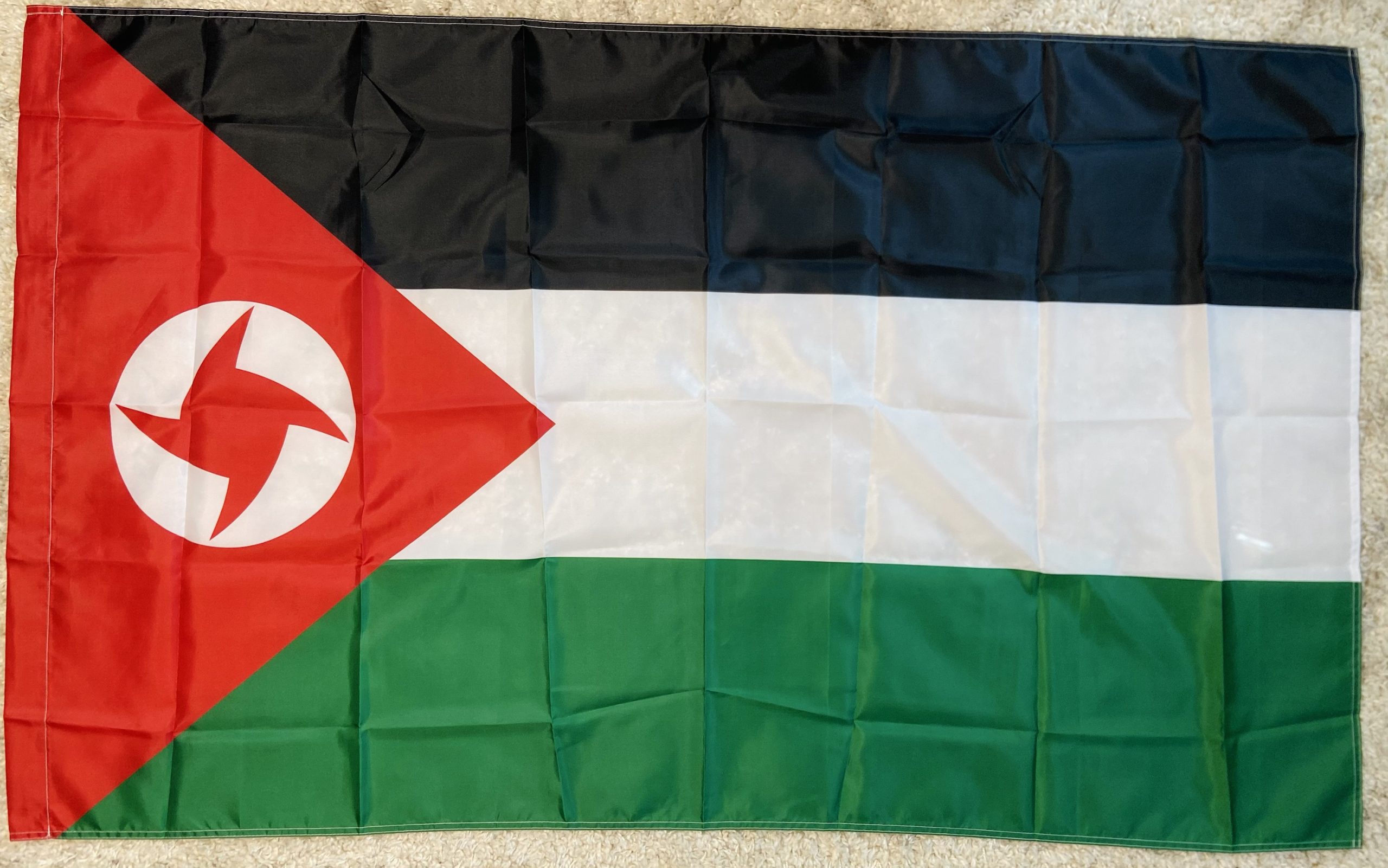 Presenting the SSNP Palestine Flag, a meticulously crafted reproduction symbolizing the historical and cultural significance of the Syrian Social Nationalist Party's support for Palestine. Measuring 150 cm in length and 90 cm in height, this flag is made from durable polyester, ensuring vibrant colors and long-lasting durability. The flag features the iconic Palestinian colors with the SSNP symbol prominently displayed within the red triangle, representing unity and resilience. Ideal for collectors, reenactors, archivists, and historians, this versatile flag is perfect for historical reenactments, educational displays, and archival purposes. It comes with reinforced edges and two metal grommets for easy hanging on flagpoles, walls, or within display cases. Add this symbolic SSNP Palestine Flag to your collection today and honor the rich history of resistance and solidarity.