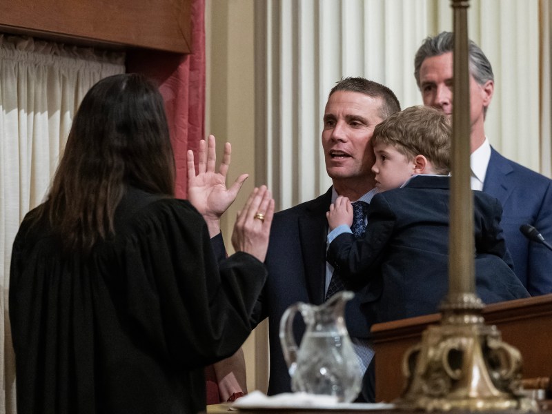 State Sen. Mike McGuire, a Democrat from Healdsburg, holds his son Connor as he is sworn in as Senate president pro tempore by California Supreme Court Chief Justice Patricia Guerrero on Feb. 5, 2024. Photo by Hector Amezcua, Sacramento Bee via Pool