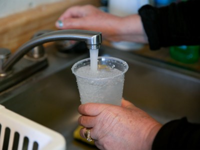 Aracel Fernandez fills a cup with tap water at her home on Nov. 10, 2020. Photo by Anne Wernikoff for CalMatters