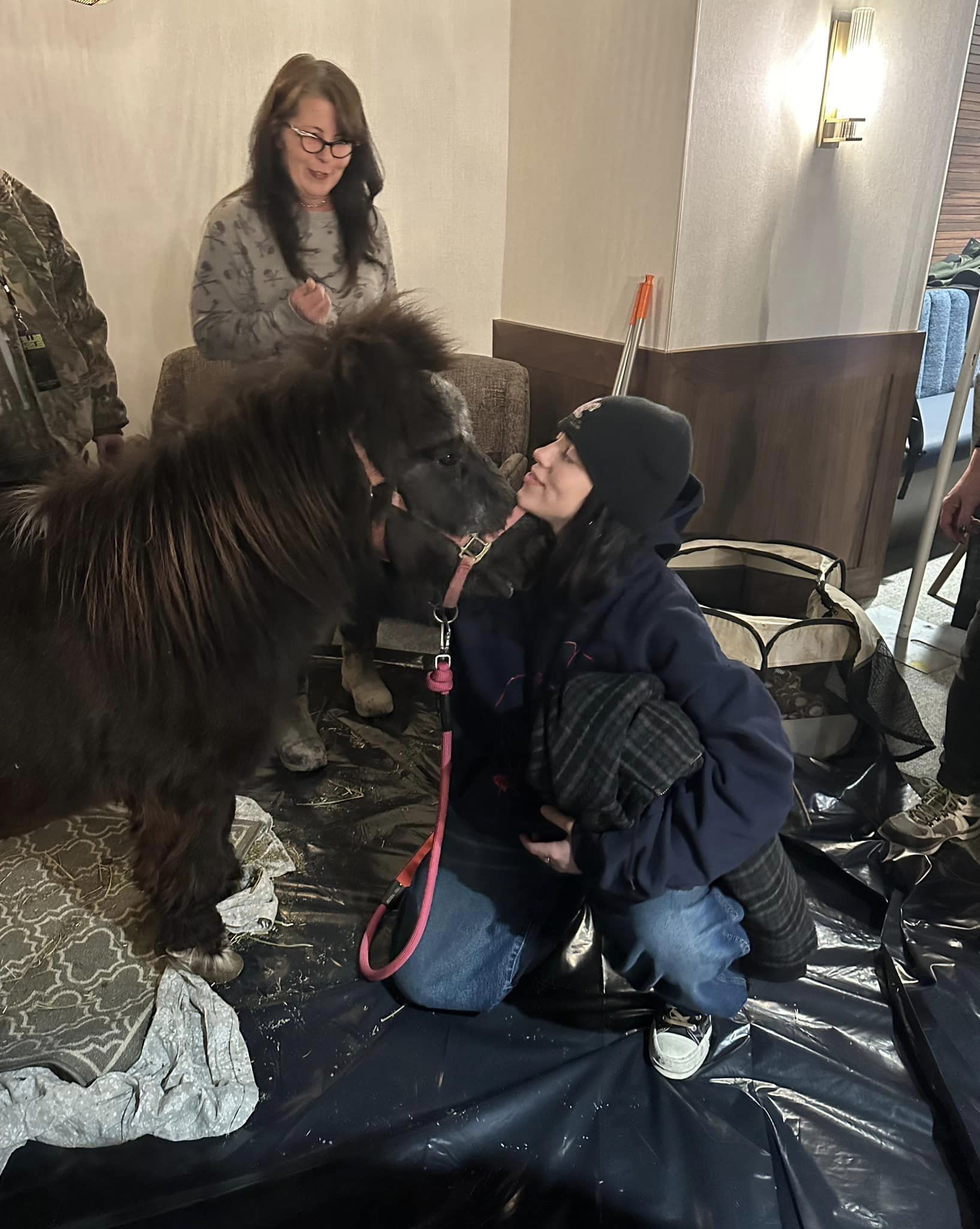 Billie Eilish snuggles with a puppy and pony from Brighter Days Dog Rescue and Broken Shovels Farm Sanctuary before performing at Ball Arena in Denver on Nov. 19, 2024. (Courtesy of Becca Orin)