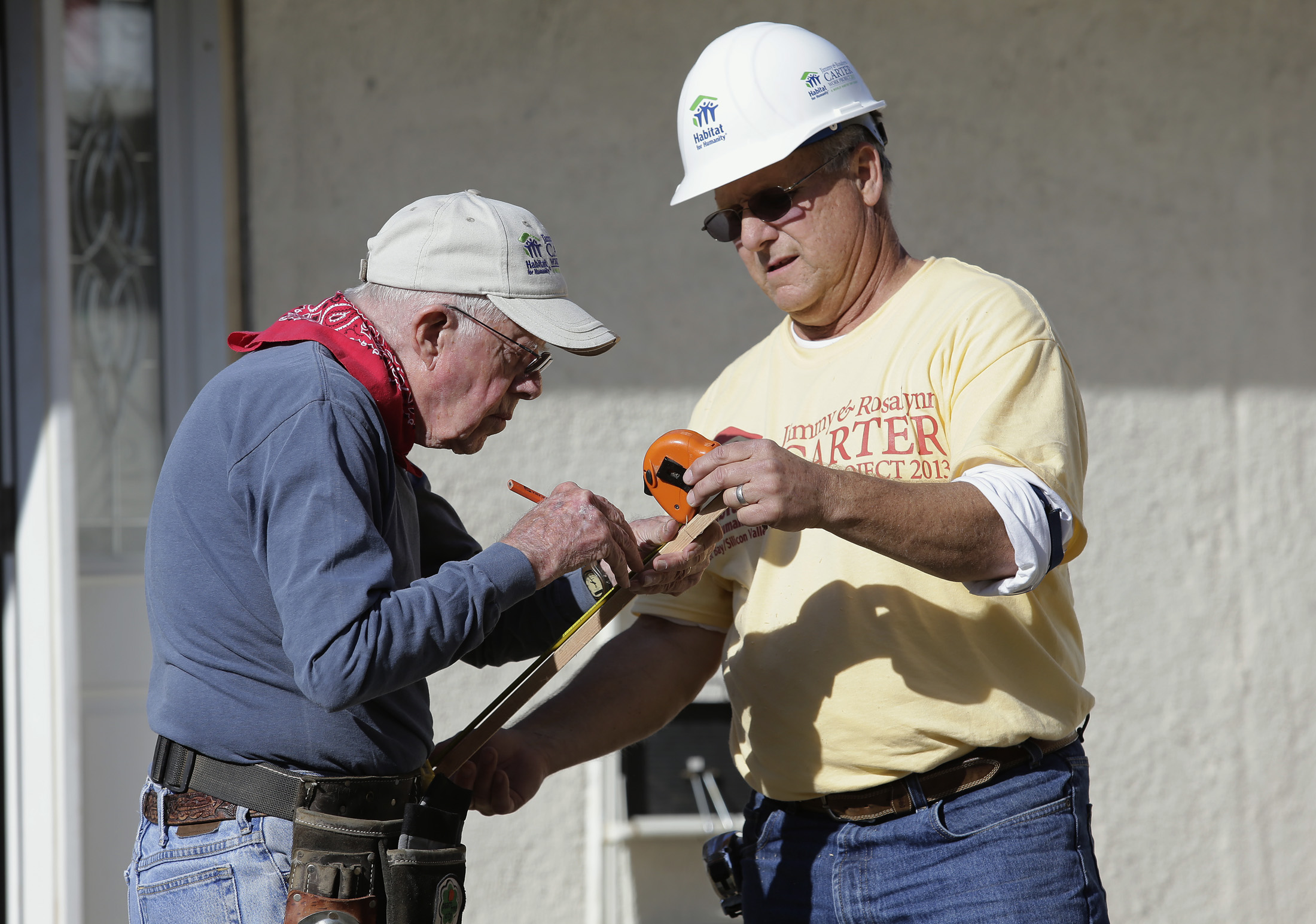 Former U.S. President Jimmy Carter takes a measurement with the help of Maury Furness, right, as they install a front door of a home on Terilyn Ave. in San Jose, Calif. on Tuesday, Oct. 8, 2013. Former President Carter and the first lady, Rosalynn Carter, helped volunteers rehabilitate the home as part of Habitat for Humanity's 30th anniversary of the Jimmy & Rosalynn Carter Work Project. Furness is a House Leader for Habitat for Humanity. (Gary Reyes/Bay Area News Group)