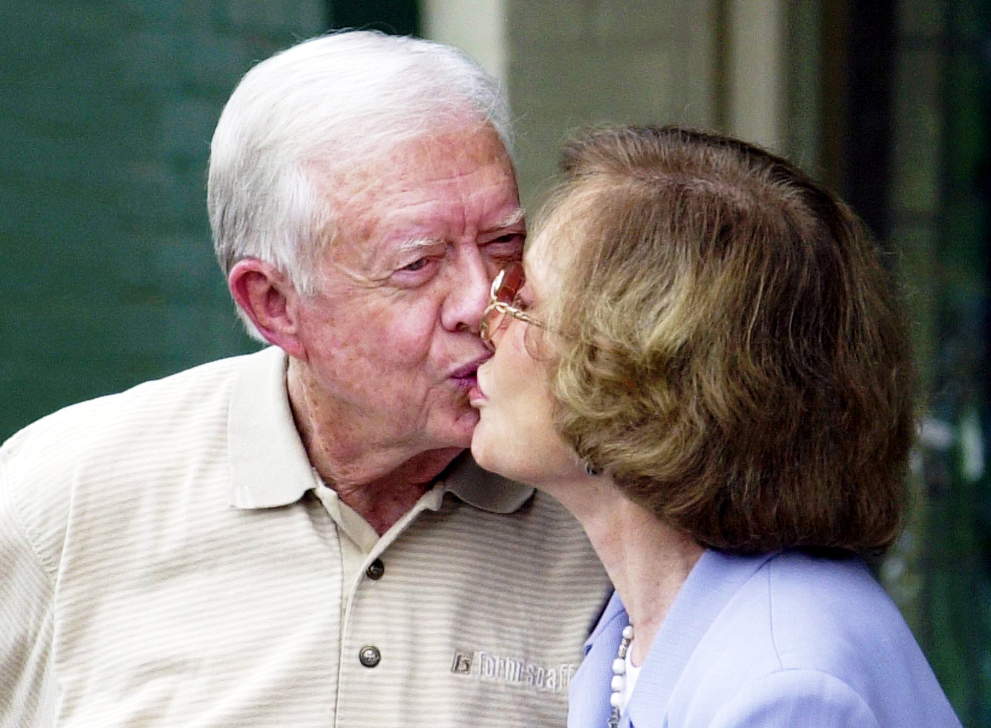 Former President Jimmy Carter kisses his wife Rosalynn after holding a news conference in Plains, Ga., Friday, Oct. 11, 2002, to discuss his thoughts on being awarded the Nobel Peace Prize. Carter won the prize Friday, more than two decades after he left the White House with the nation's mood darkened by economic malaise, the Iranian hostage crisis and the energy crisis. His post-presidency work has been more successful, as he has mediated conflicts across the globe, fought for human rights and tried to improve health care in the Third World. (AP Photo/John Bazemore)