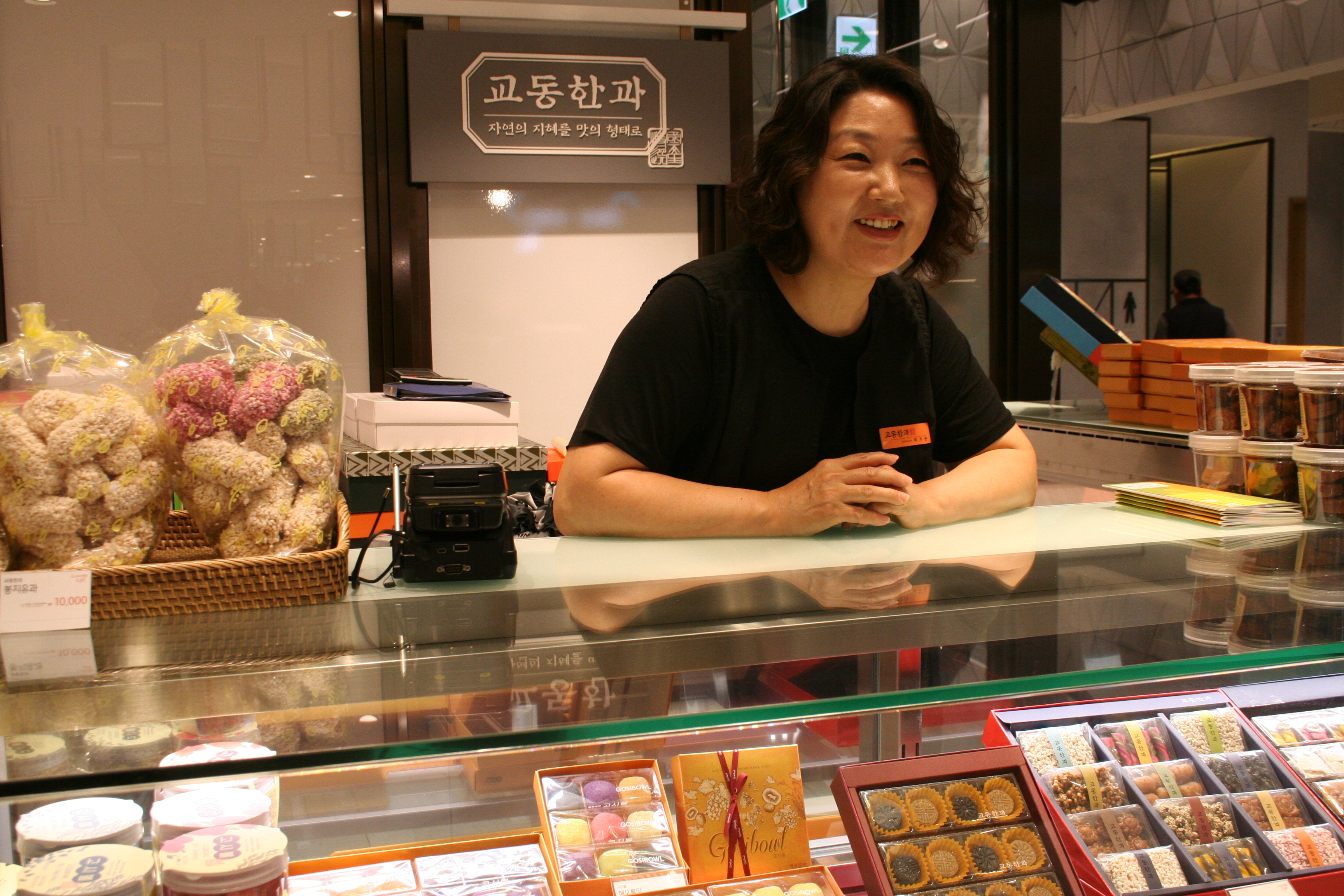 A worker serves customers at Gyodong, a small shop selling traditional Korean delicacies at the Lotte Department Store in Jamsil, Seoul, South Korea. (Caroline Wong)