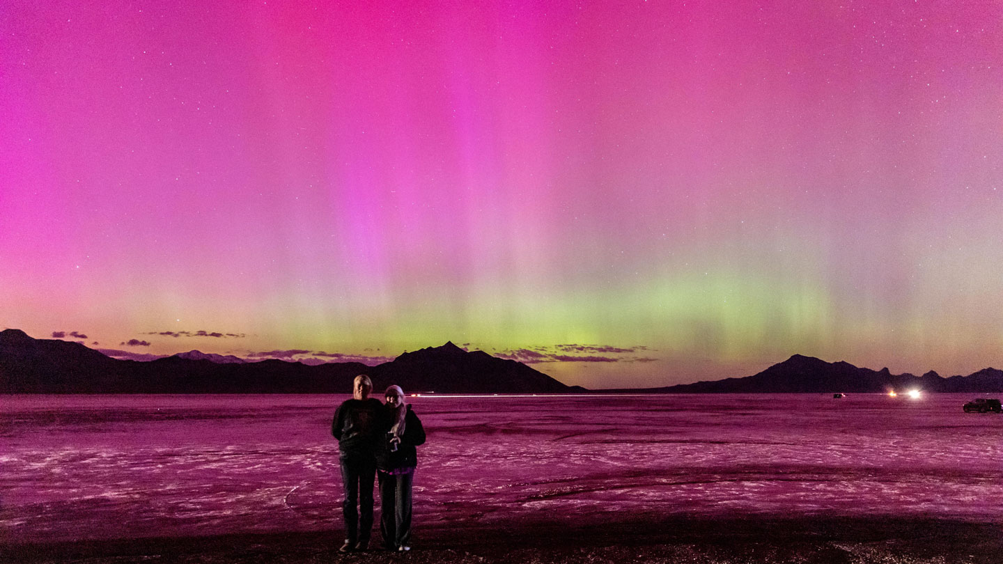 An image showing beautiful pink and green auroras over Bonneville Salt Flats in Utah on May 10