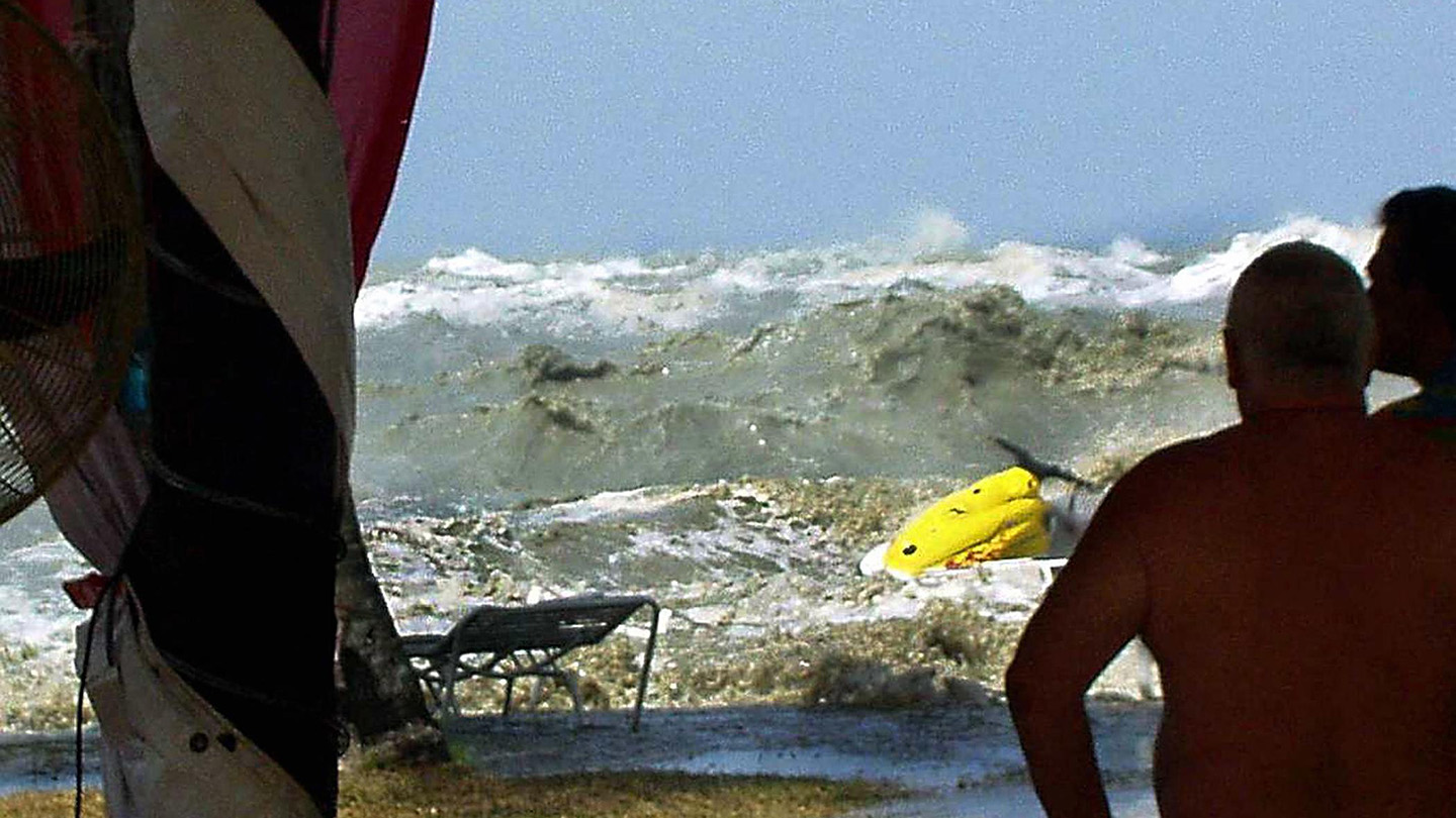 A tsunami approaches people on a coastline in Malaysia on December 26, 2004.