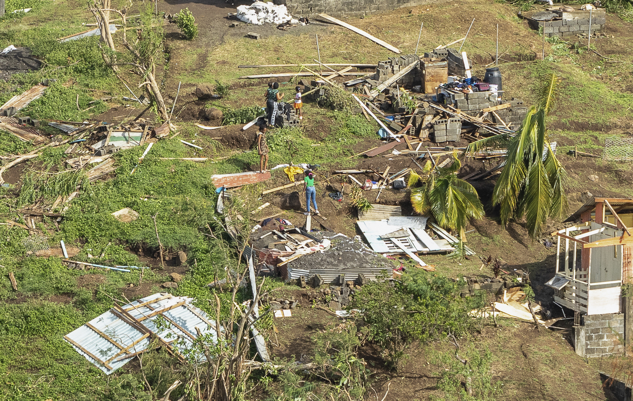 Family members survey their home destroyed in the passing of Hurricane Beryl, in Ottley Hall, St. Vincent and the Grenadines, Tuesday, July 2, 2024. (AP Photo/Lucanus Ollivierre)