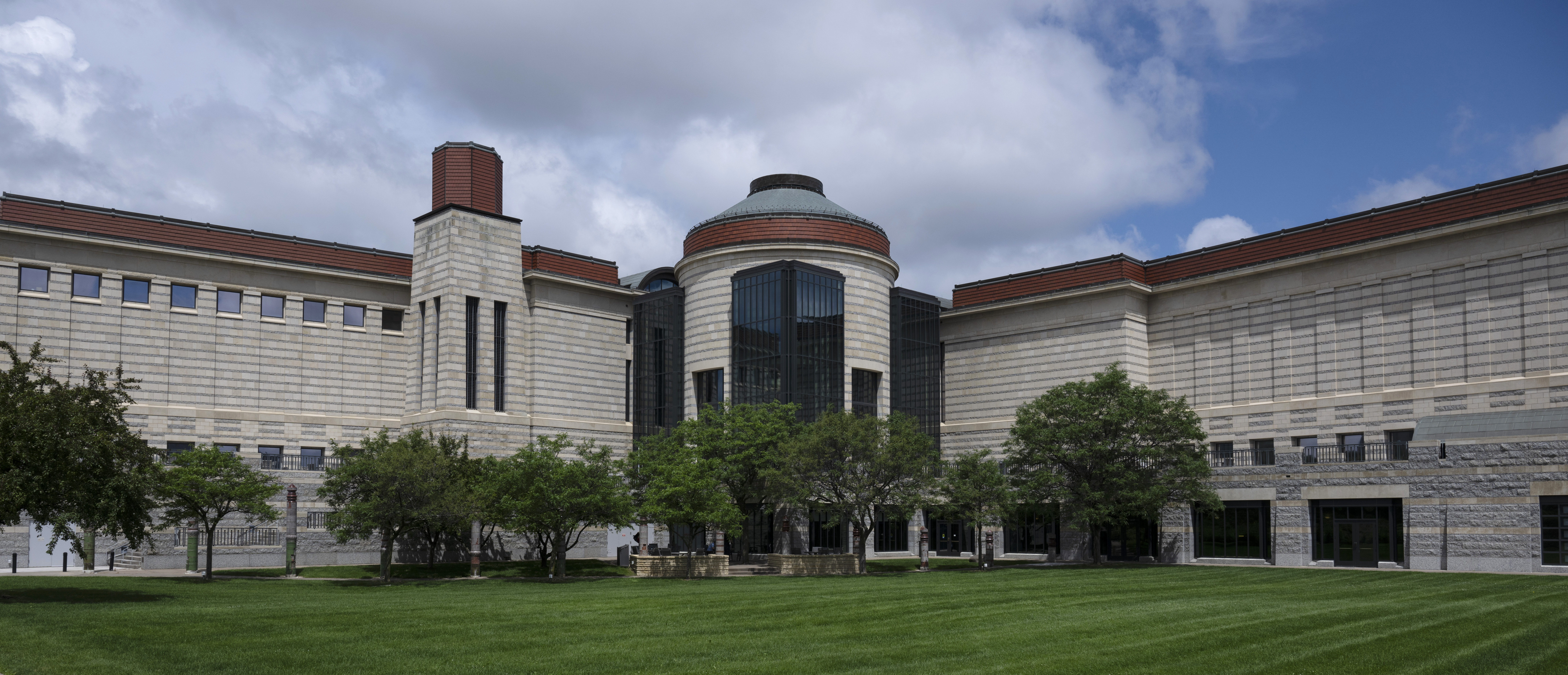 An L-shaped building with a round tower at its center.